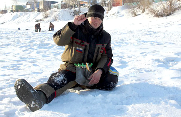 Рыбак на зимней рыбалке ловит на мормышку. зимняя рыбалка